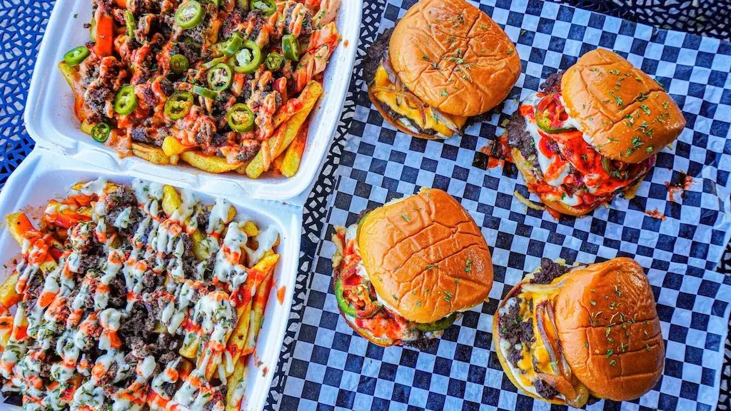 Crypto Burger burgers and loaded fries arranged for a group order