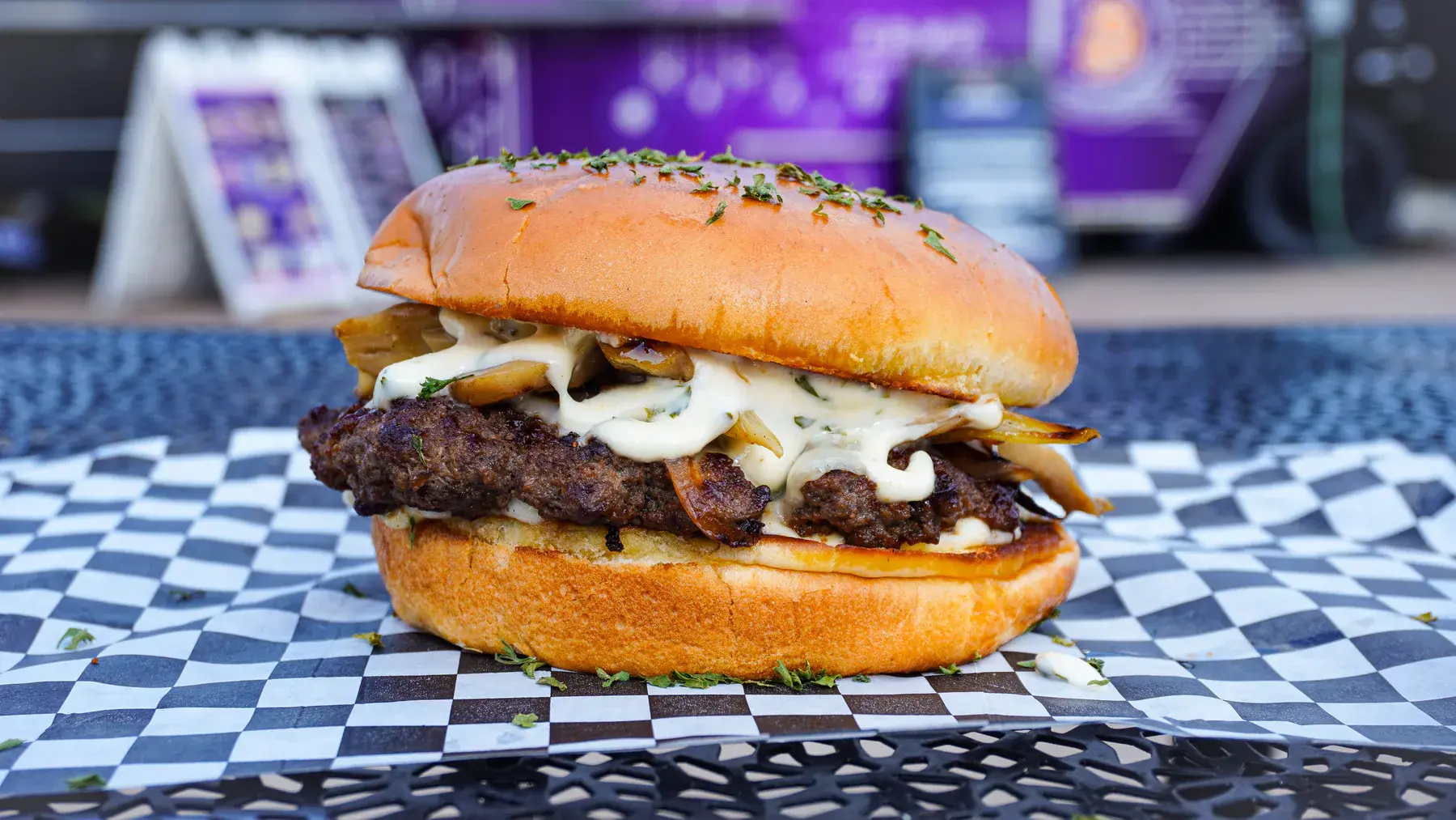 NFT Burger with sauteed mushrooms, onions, white American cheese, and FOMO sauce